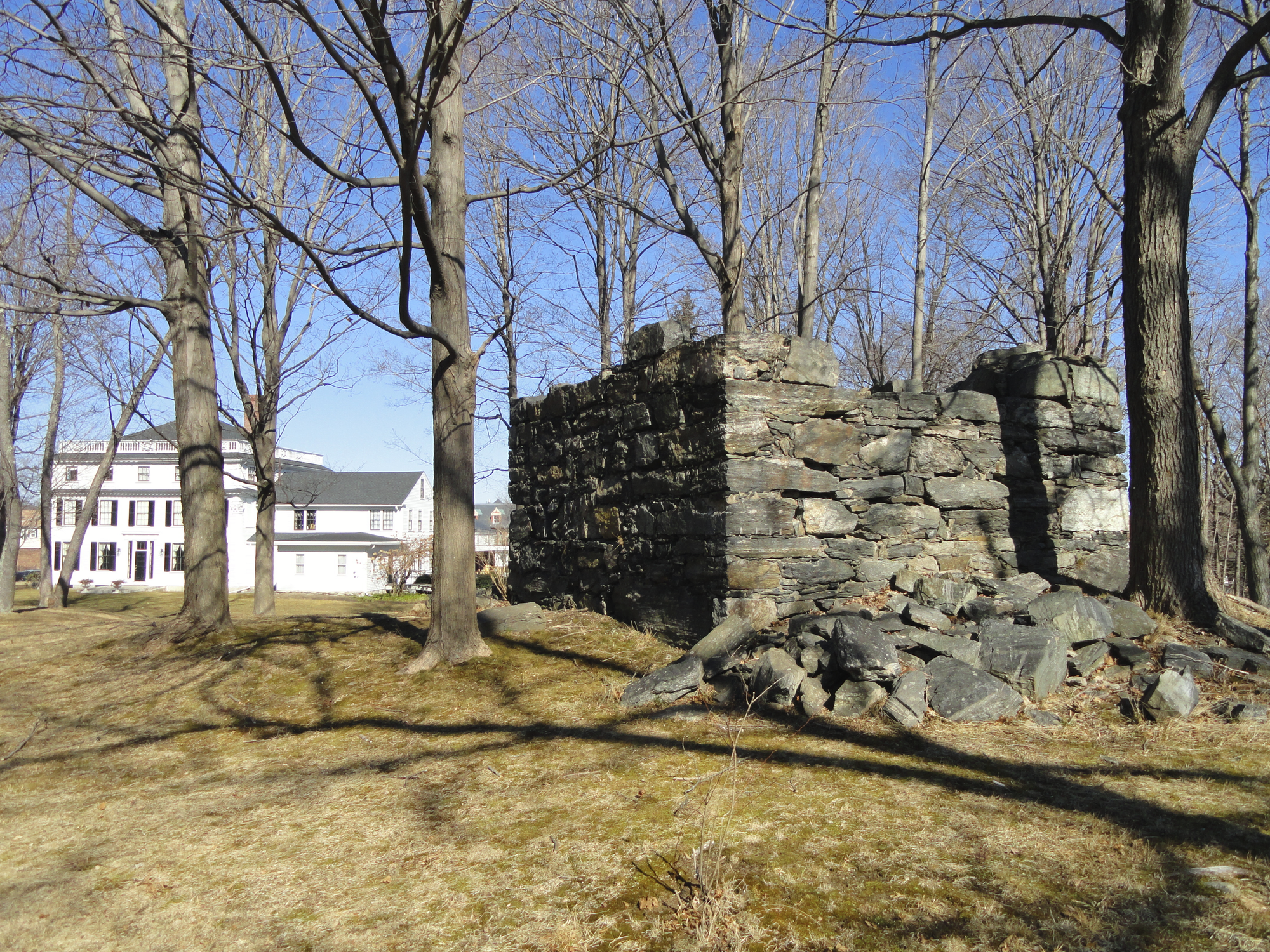 A stone cistern. Asa Waters Mansion can be seen in the left rear.