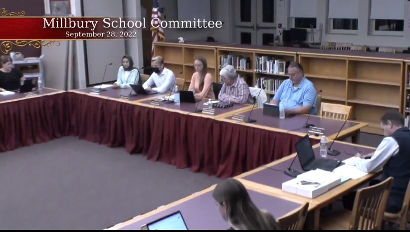 Five people sit at a table for a school committee meeting.