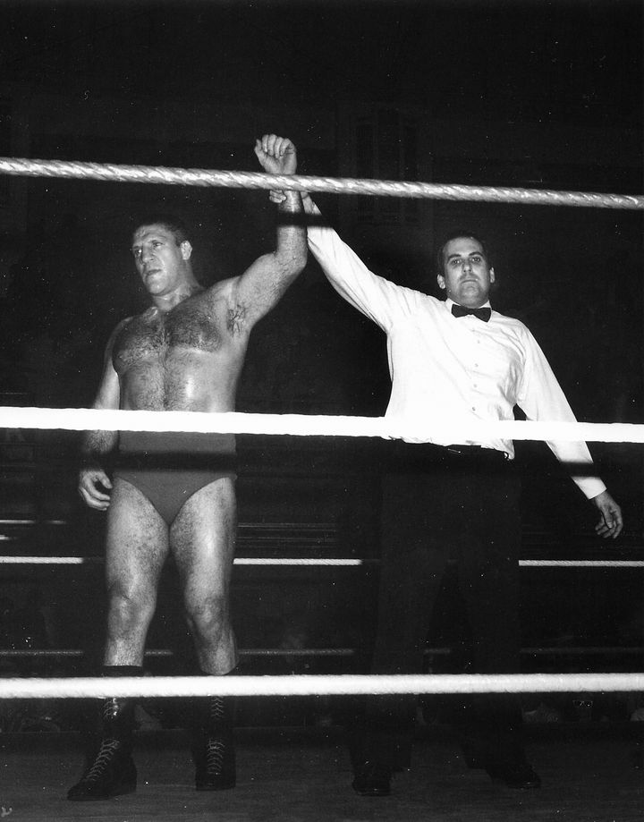Referee Dave Dwinell raises the arm of Bruno Sammartino inside a wrestling ring