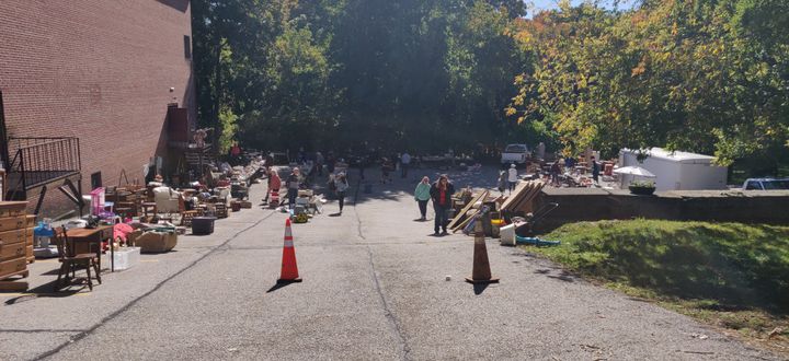 Several tables and items on display at a yard sale.